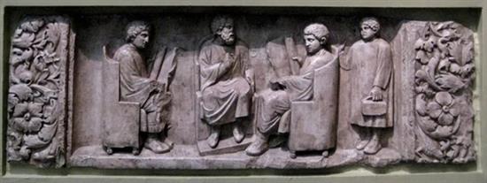 约180-185年的古罗马墓碑，老师与学生坐在中央，手上拿着展开的卷轴，右侧一名书僮提着装着笔墨的小箱子